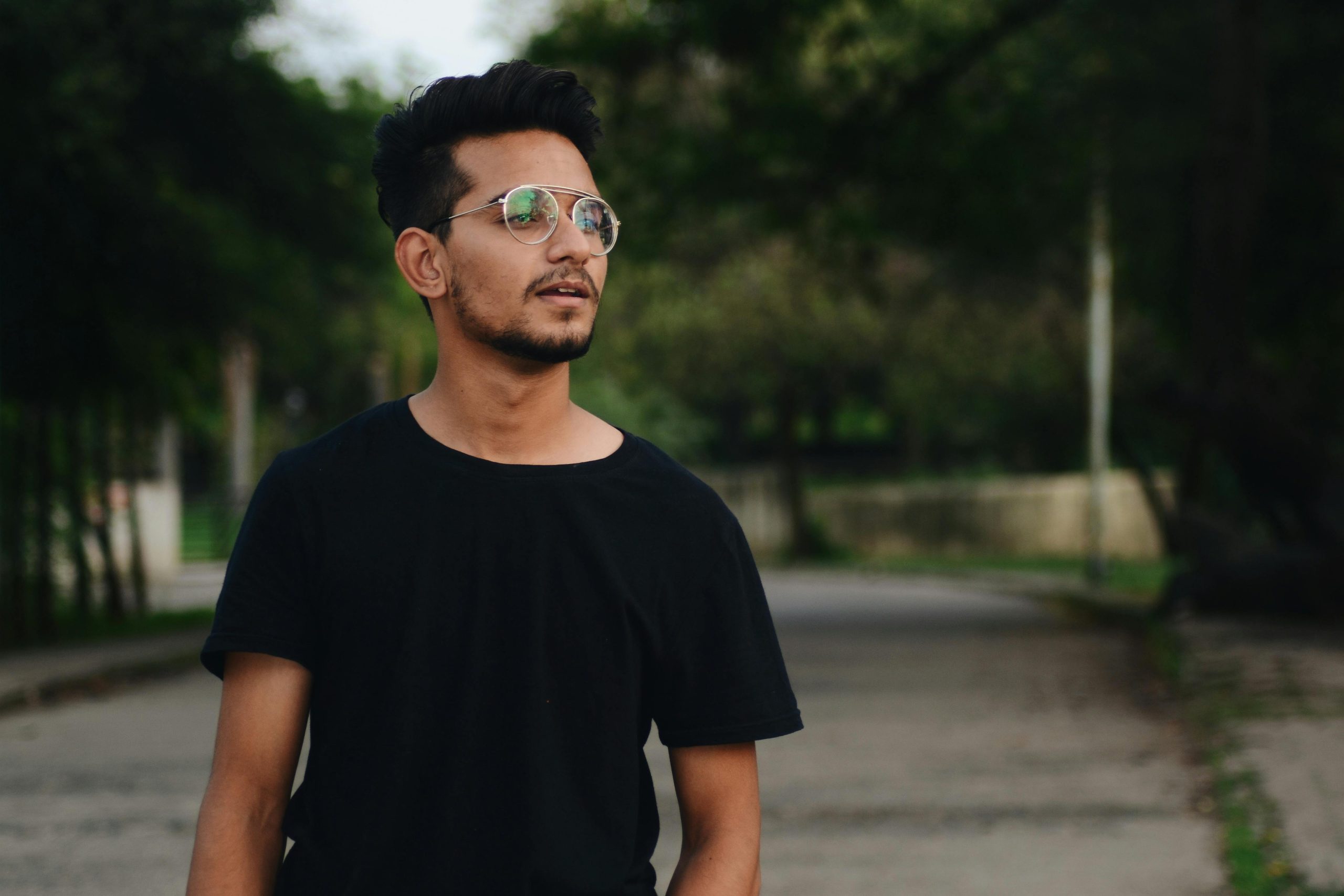 Man Wearing Eyeglasses Standing on Gray Road